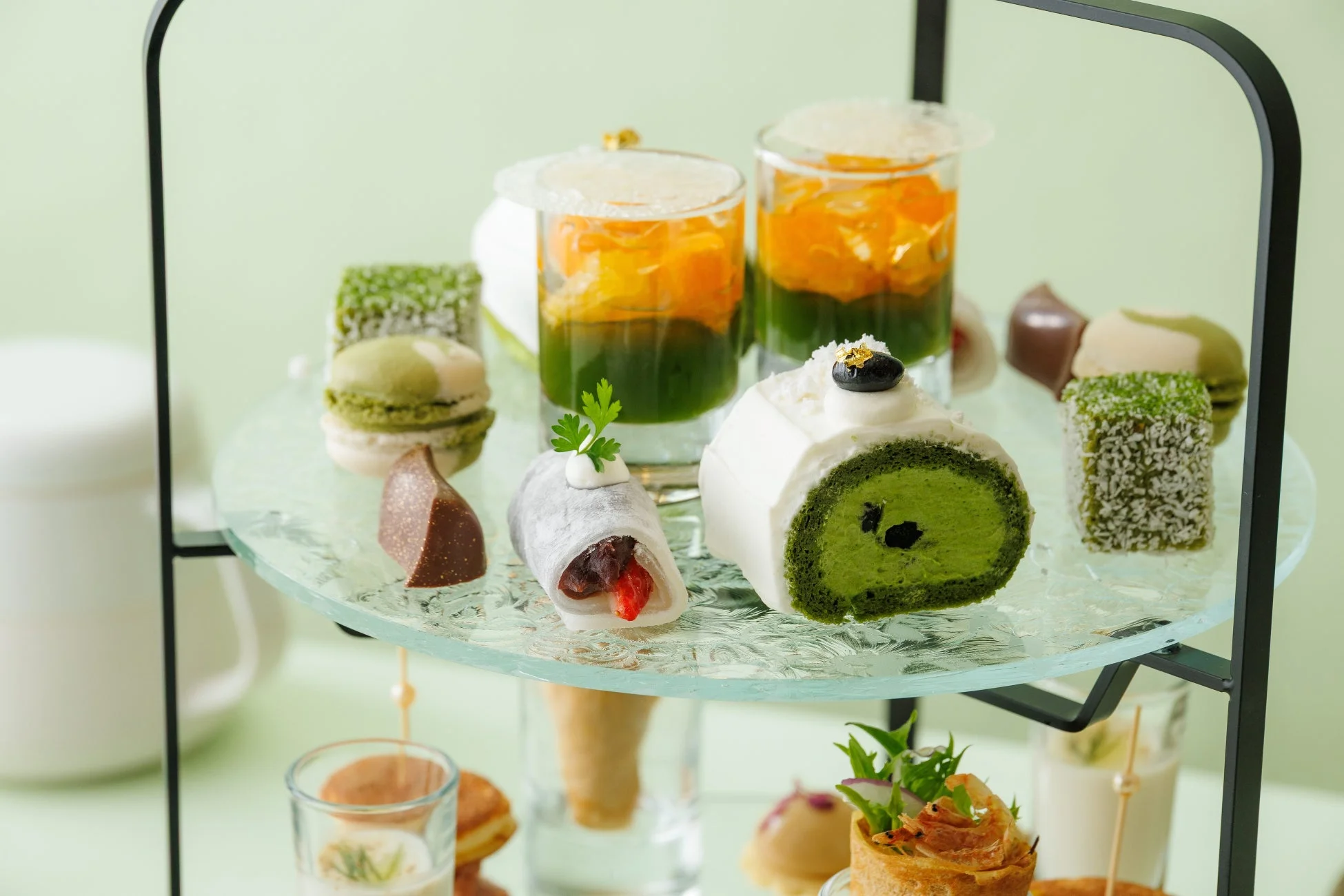 美しい二段のスタンドに盛り付けられた、抹茶風味のロールケーキやマカロン、和菓子など彩り豊かなアフタヌーンティーのスイーツセット