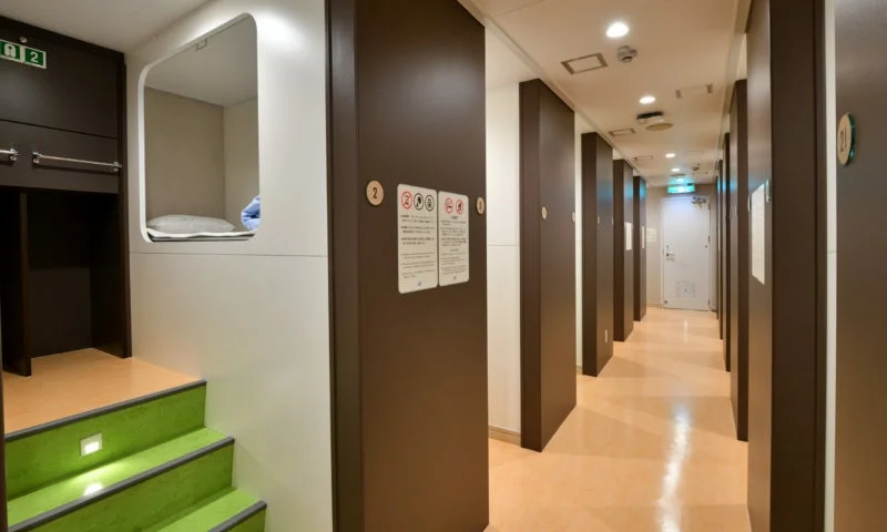 カプセルホテルまたは類似の宿泊施設の通路と寝室エリア