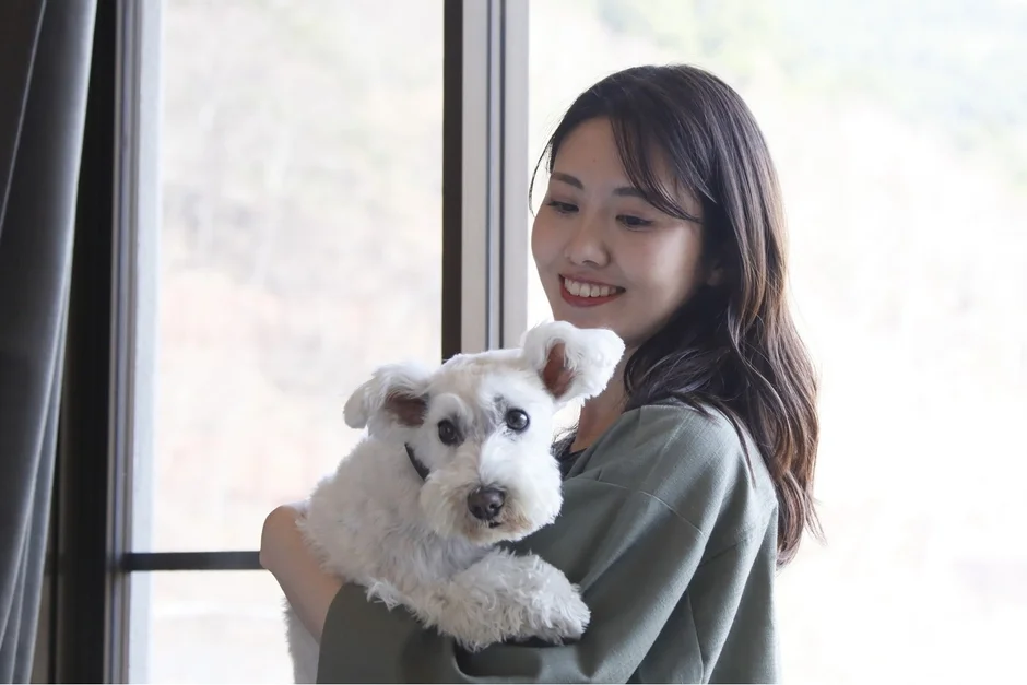 窓辺で愛犬と過ごす女性