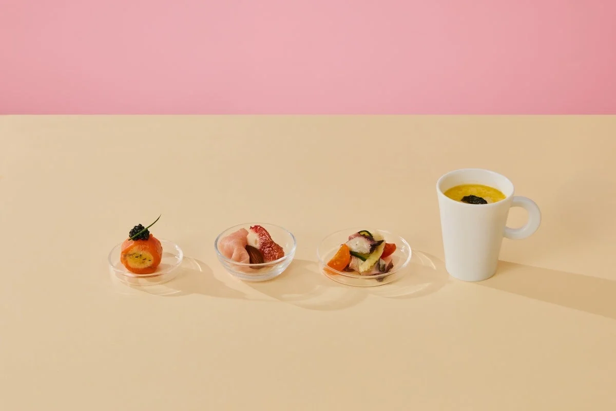 ミニマルなアミューズ4品が並べられた食卓の様子。